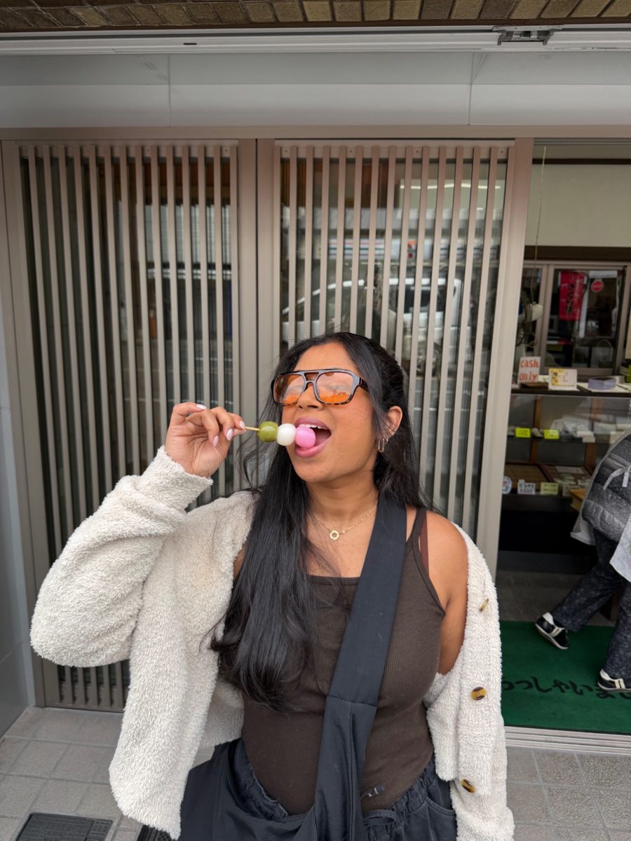 Shruthi enjoying a sweet treat on a street in Japan