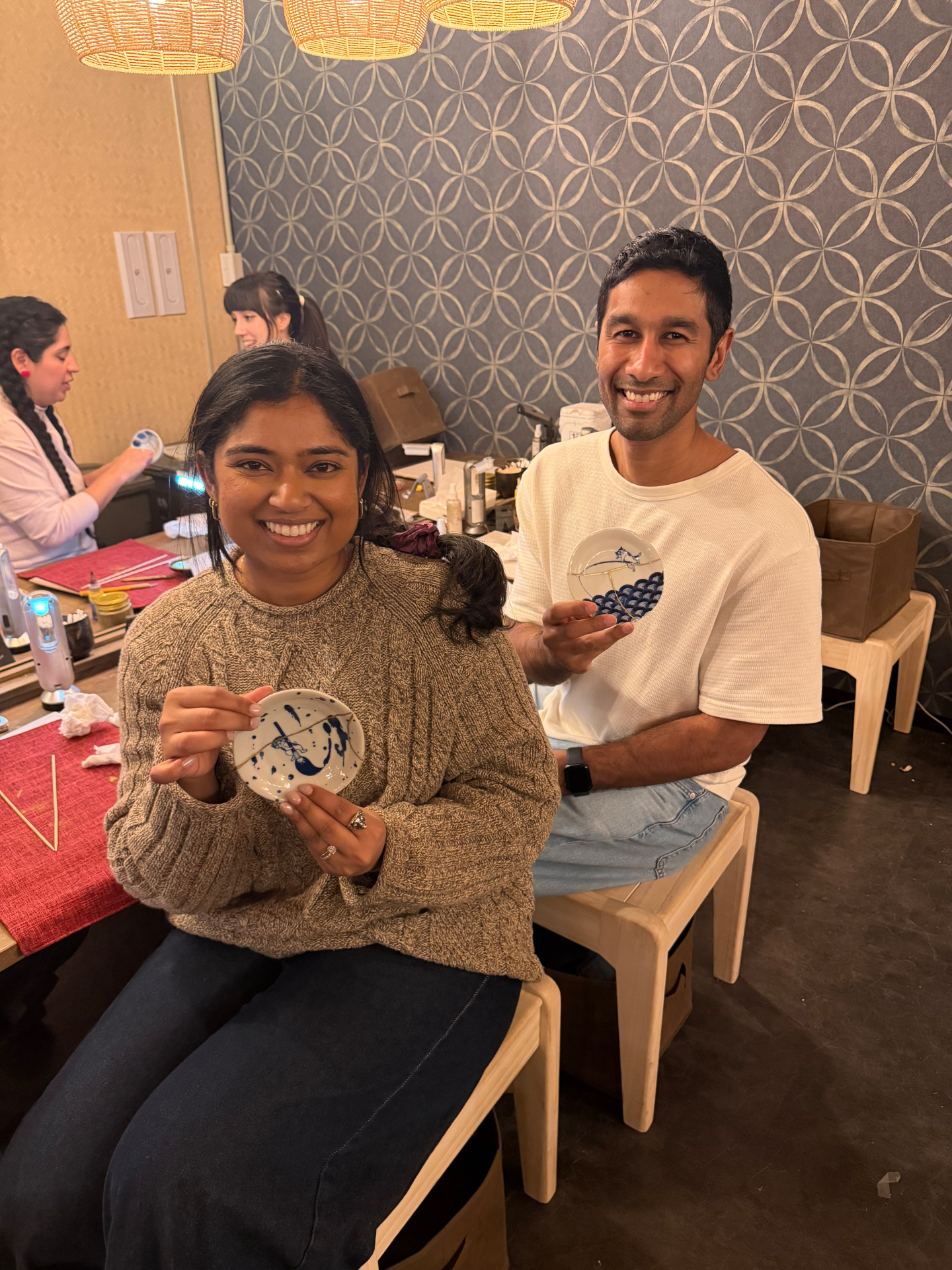 Shruthi and her husband holding pottery from a kintsugi workshop